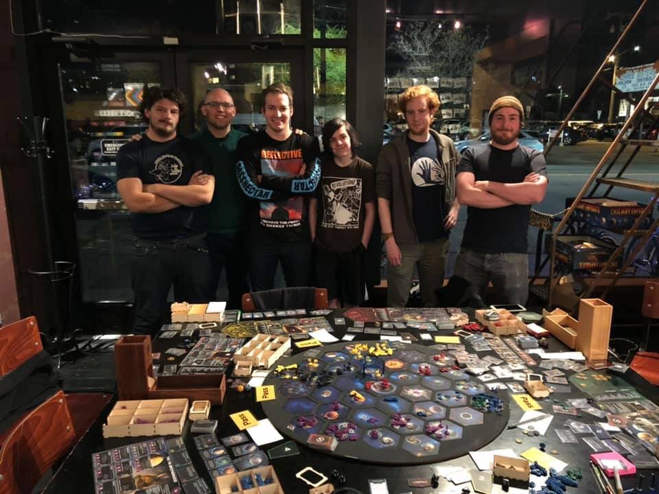  The 6 players in the 2019 Seattle Twilight Imperium Tournament final pictured next to the board 