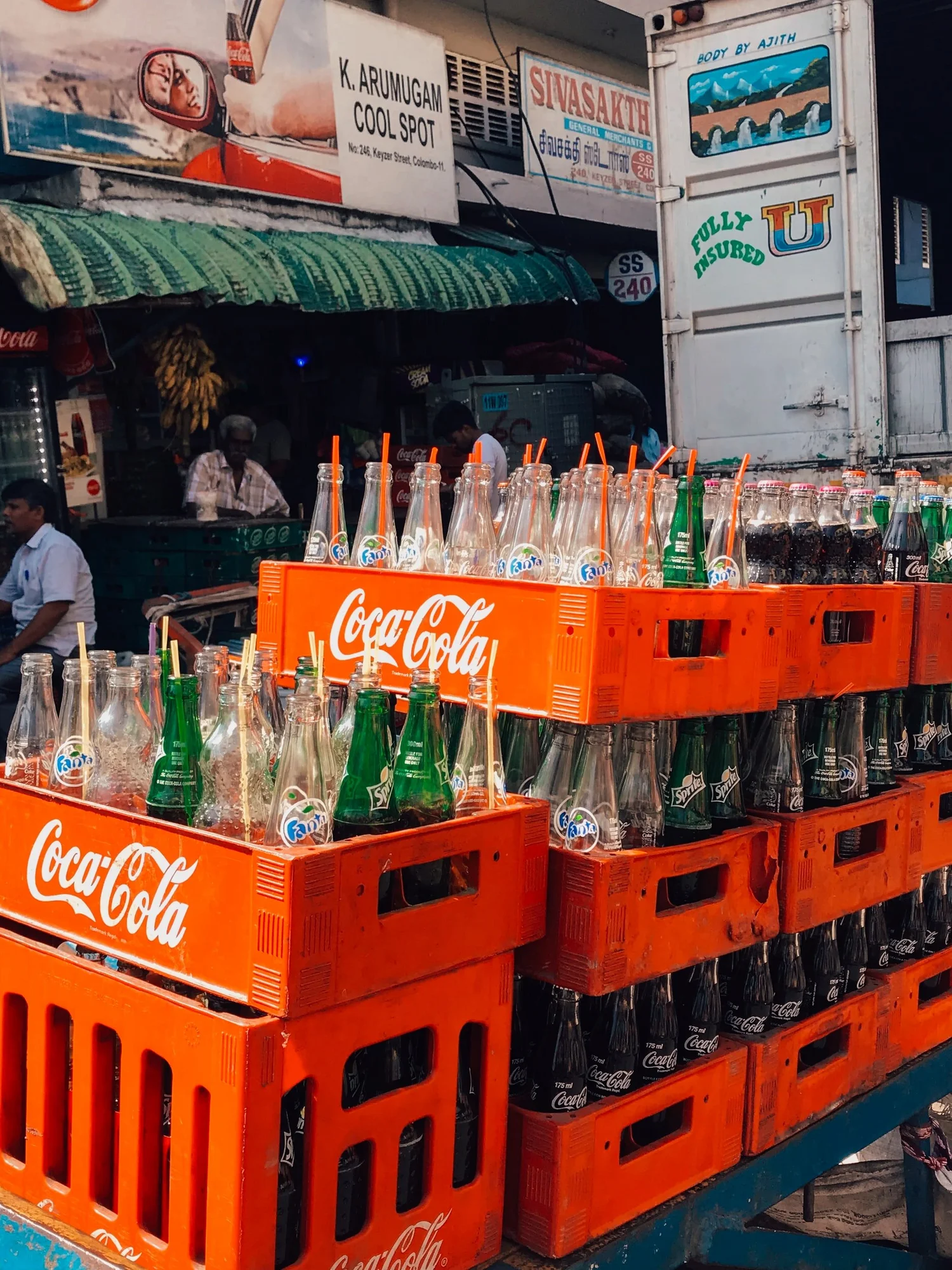 Empty soda bottles sit in pallets by a market