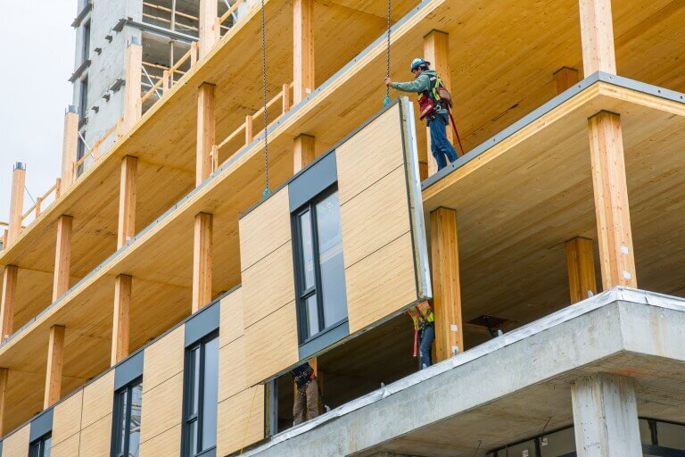   Workers install a CLT panel for Brock Commons in Vancouver. (Credit:    Naturally Wood   )  
