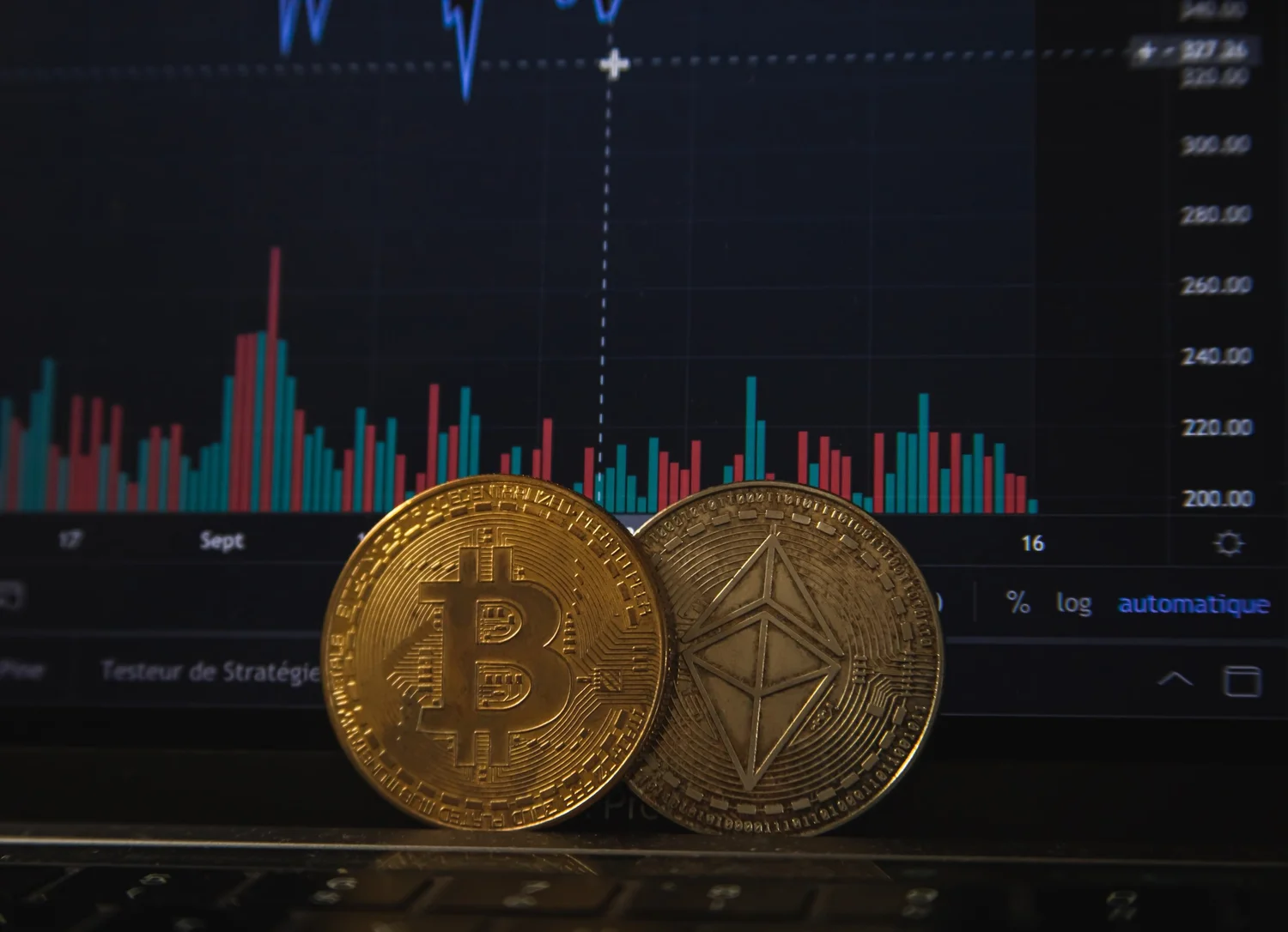 Physical Bitcoin and Ethereum coins in front of a market chart