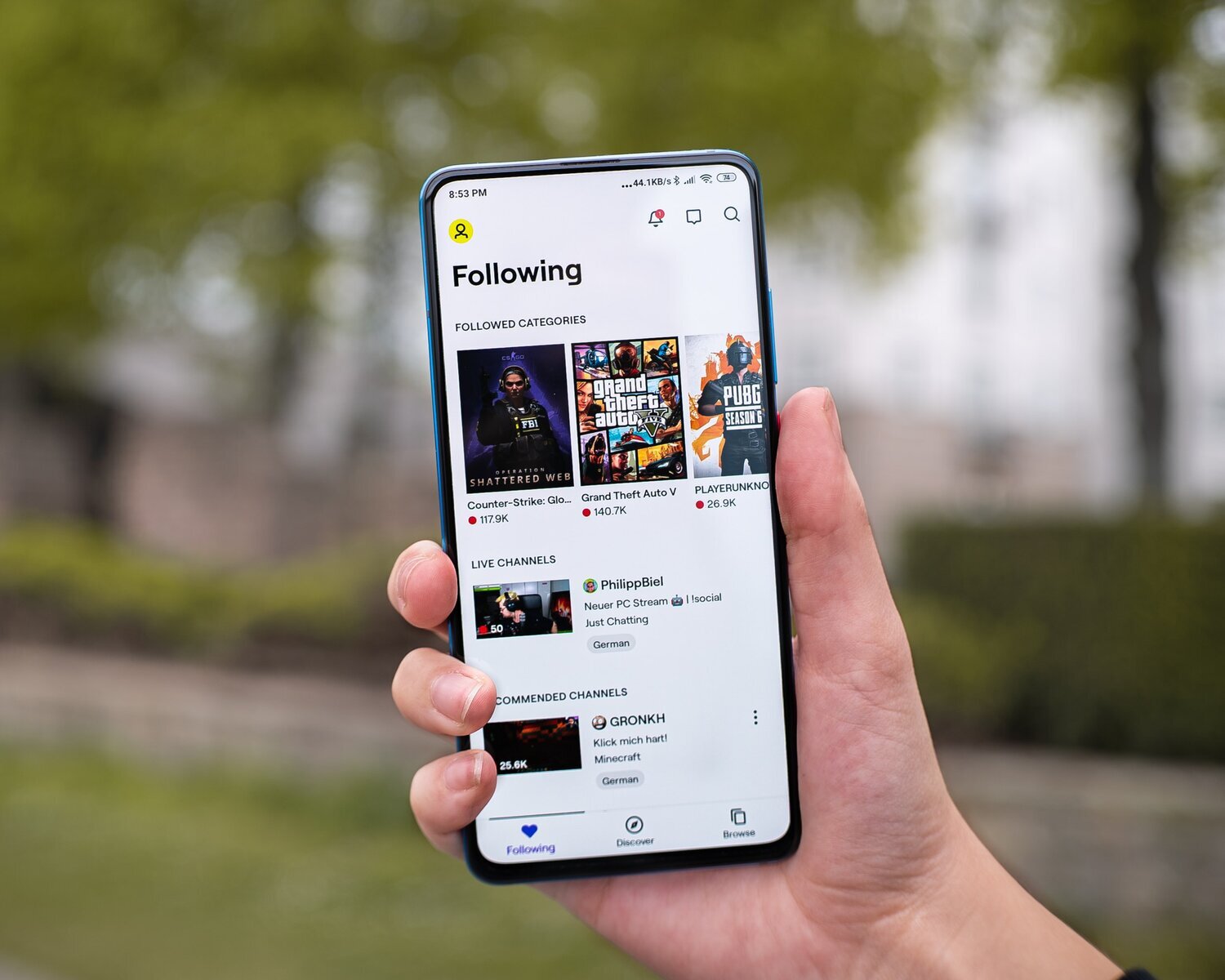 Hand holding phone with Twitch app open